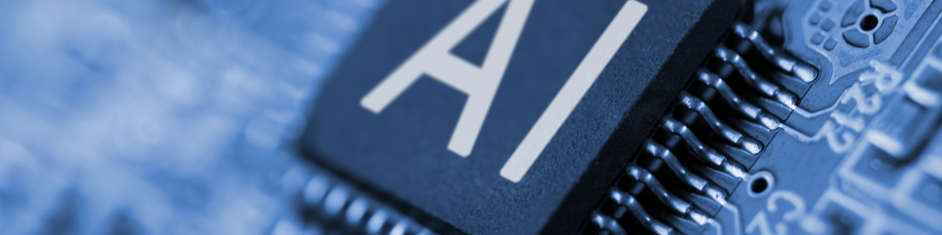 Close-up of a computer circuit board with a central chip labelled “AI,” symbolising artificial intelligence integration in executive decision-making.