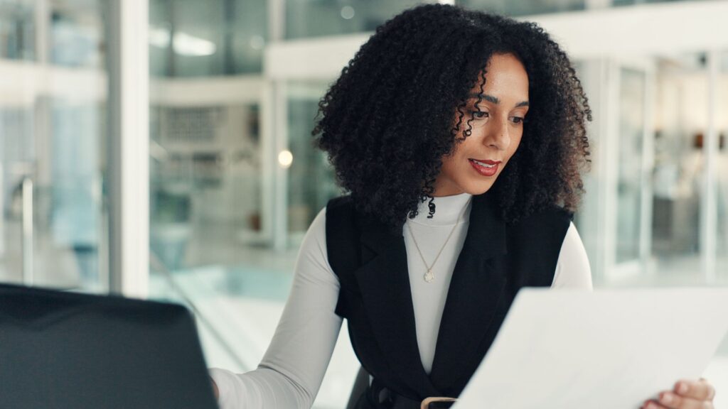 HR professional reviewing UK employment law documents, including IR35 and worker classification guidelines, on a laptop.